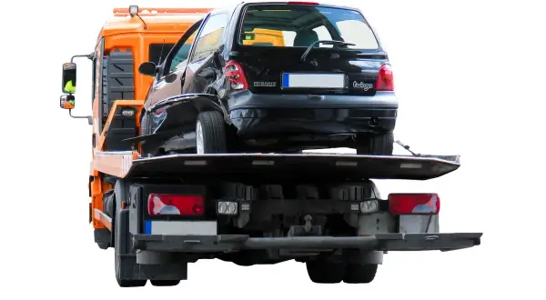 Uszkodzony czarny Renault Twingo jest ładowany na lawetę. Widać, że można holować samochód po wypadku.