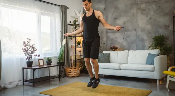 Man doing jump rope workout at home, a great alternative to burpees for cardio.