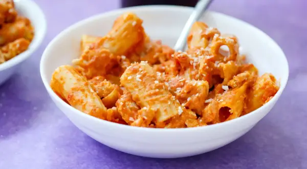 Ein Teller Rigatoni mit cremiger Tomatensoße und Parmesan, ein Klassiker des Neapel Essens.