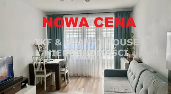 Nowa cena nieruchomości! Salon z jadalnią, kanapą i stołem. Okna z zasłonami.