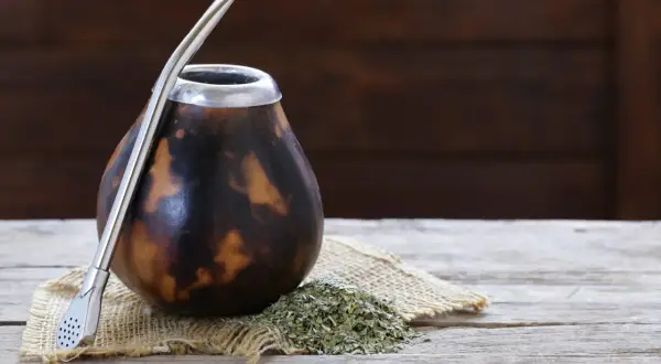 Naczynie z tykwy palo santo, gotowe do pierwszego użycia. Obok yerba mate i metalowa bombilla.