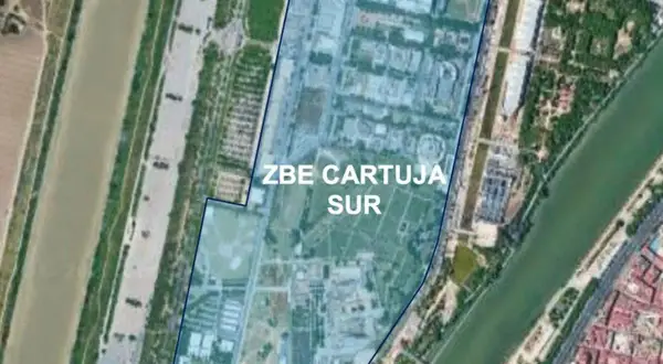 Vista aérea de la zona ZBE Cartuja Sur en Sevilla, delimitada en azul, junto a un río y edificios.