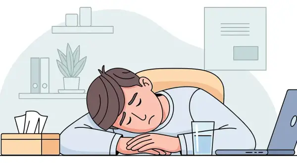 Ein Mann schläft erschöpft auf seinem Schreibtisch ein, ein Glas Wasser und Taschentücher daneben. Ein Bild für stillen Burnout.