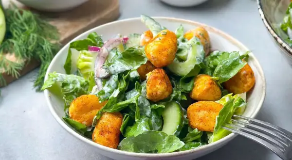 Knuspriger Gnocchi Salat mit Gurken, Zwiebeln und cremigem Dressing. Ein leckeres Gericht für jede Gelegenheit.
