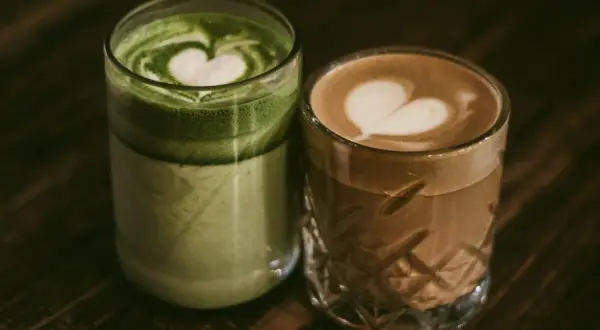 Dwa napoje z pianką w kształcie serca: zielona matcha i kawa. Czy kofeina pobudza? Te napoje z pewnością dodadzą energii.