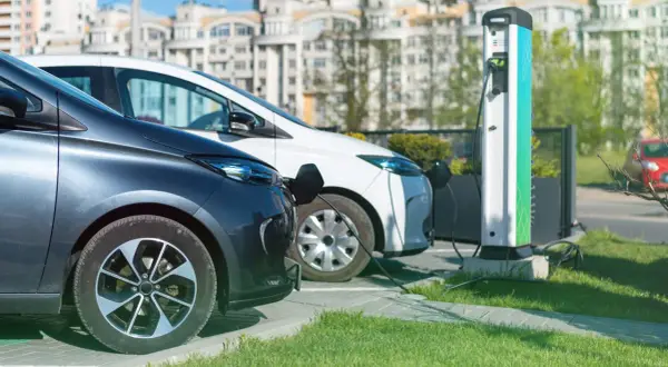 Due auto elettriche in carica, un esempio di come la normativa parcheggi auto elettriche favorisce la mobilità sostenibile.
