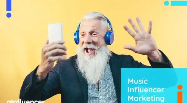An excited older man with a long white beard wears headphones and holds a phone, ready to share his thoughts on music influencer marketing.