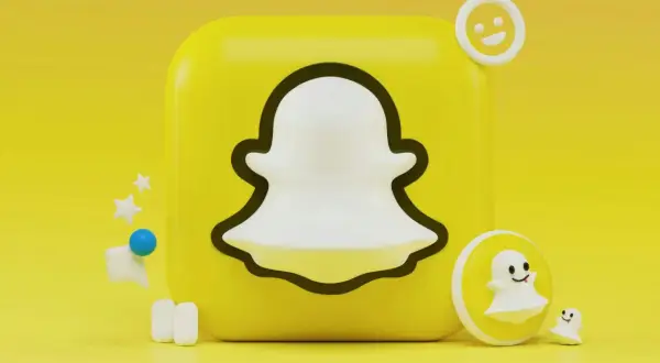 Ikona Snapchata z małymi duchami i emotikonami na żółtym tle.