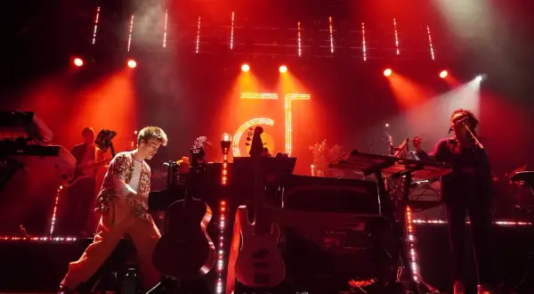 Jacob Collier and his band perform on a stage bathed in red light, with instruments and a large "GT" logo visible.