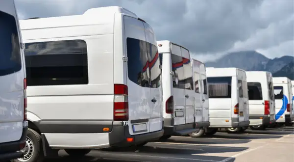 Rząd białych busów gotowych do wyjazdu z Zakopanego na Palenicę Białczańską.