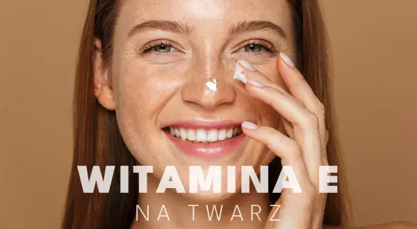 Uśmiechnięta kobieta z piegami aplikuje krem pod oczy. Witamina E na twarz dla promiennej cery.