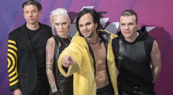 Zespół The Rasmus na koncercie, w tym wokalista Lauri Ylönen w żółtym futrze.