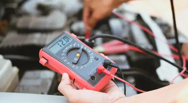 Diagnostic d'une électrovanne turbo défectueuse symptôme : un mécanicien utilise un multimètre pour tester le circuit.