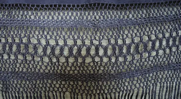 Detalle de cómo hacer flecos para mantones, con un intrincado tejido de macramé y borlas.