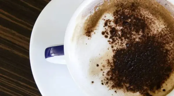 Un delizioso cappuccino a casa, con schiuma soffice e cacao spolverato. Un momento di puro piacere.
