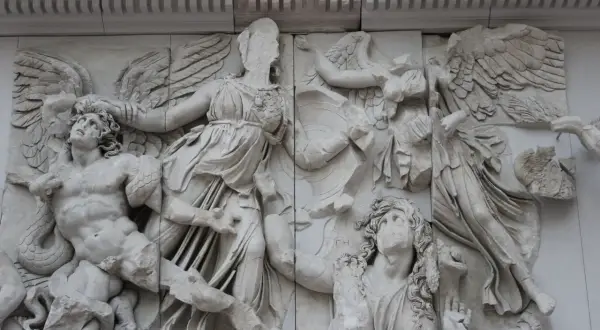 Antyczne rzeźby, jak ten fragment fryzu z Pergamonu, ukazują dynamiczne sceny walki. Widać tu skrzydlate postacie i walczących ludzi, co stanowi wspaniałe przykłady rzeźby antycznej.