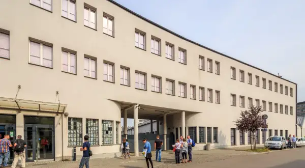 Dawna fabryka Oskara Schindlera w Krakowie, dziś muzeum. Na fasadzie widoczne okna i wejście, przed którym stoją ludzie.