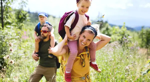 Familia disfrutando de benasque rutas sencillas. Niños a caballito, sonrisas y naturaleza.