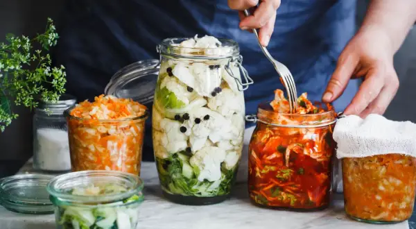 Här är flera burkar med fermenterad mat, inklusive surkål och kimchi, redo att avnjutas.