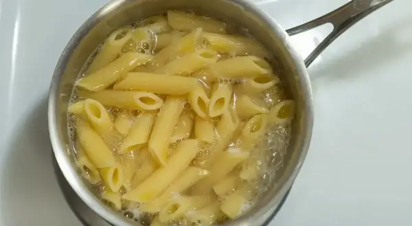 Penne rigate gotują się w garnku na kuchence.