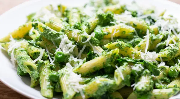 Penne z zielonym pesto, groszkiem i parmezanem. Pyszna sałatka z makaronem szpinakiem i suszonymi pomidorami.