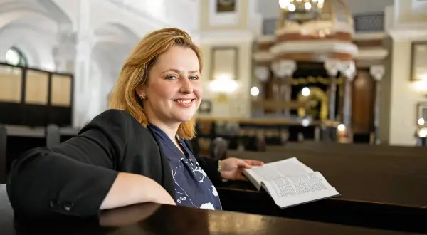 Kobieta z książką w synagodze. Czy to ona odkrywa, które polskie gwiazdy mają żydowskie korzenie i dlaczego o tym milczały?