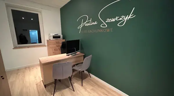 Nowoczesne biuro rachunkowe z zieloną ścianą i napisem "Paulina Szewczyk Biuro Rachunkowe".