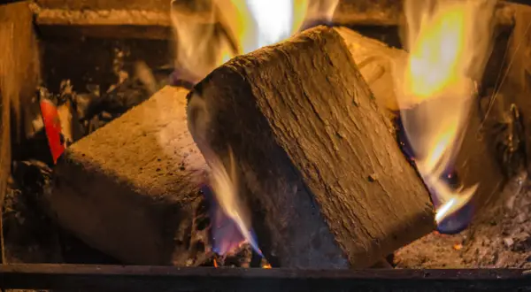Zwei Holzbriketts brennen im Kamin. Die lange Brenndauer sorgt für wohlige Wärme.