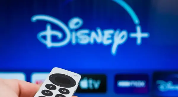 Pilot w dłoni, ekran z logo Disney+. Dowiedz się, jak dodać aplikacje do telewizora LG, by cieszyć się ulubionymi treściami.