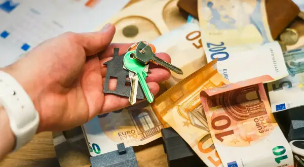 Llaves y un llavero con forma de casa sobre billetes de euros. La hipoteca de 220.000 euros parece estar cerca.