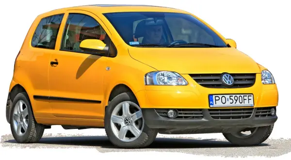 Żółty Volkswagen Fox z 2006 roku, z kierowcą za kierownicą, gotowy do jazdy.