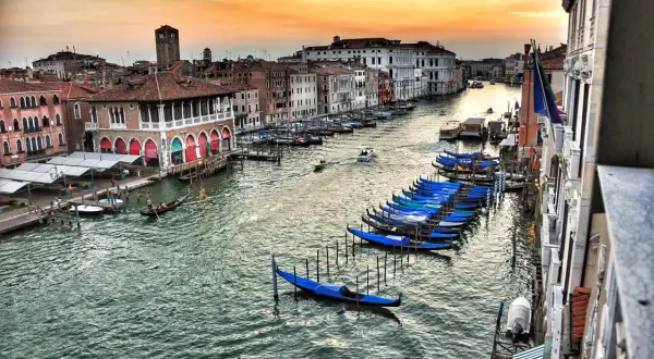 Wenecja co zobaczyć w 1 dzień: gondole czekają nad Canal Grande, a zachodzące słońce maluje niebo.