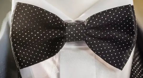 Czarna mucha w groszki, idealna do granatowego garnituru. Elegancki dodatek na specjalne okazje.