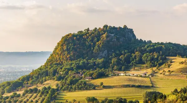 Burgruine Hohenzollern, ein Wahrzeichen Deutschlands, thront auf einem bewaldeten Berg. Die Landschaft um Singen, Deutschland, ist im Herbstlicht malerisch.