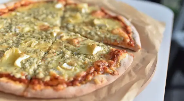 Pyszna pizza z serem pleśniowym i camembertem. Kolejność składników na cieście z sosem pomidorowym zachwyca.