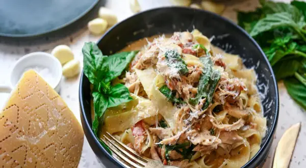 Pyszna carbonara z kurczakiem, podana z parmezanem, bazylią i czosnkiem. Idealna na obiad.
