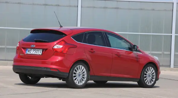 Czerwony Ford Focus MK3 kombi, gotowy do wymiany żarówki stopu.
