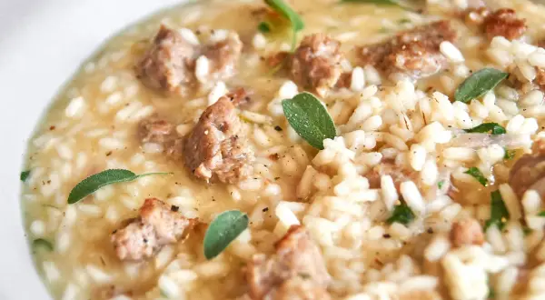 Cremiges Risotto mit herzhaften Salsiccia-Stücken und frischen Salbeiblättern.