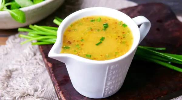 Ein cremiges Dressing für Feldsalat, verfeinert mit Senfkörnern und Schnittlauch, bereit zum Servieren.