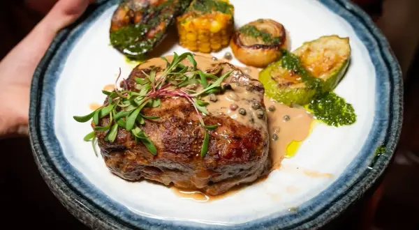 En saftig biff med pepparsås, grillad zucchini, majskolv och lök. Ett perfekt pepparsås recept för en lyxig middag.