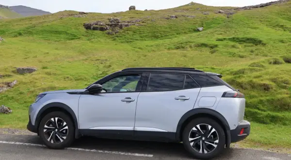 Silver Peugeot 2008 parkerad vid en grön sluttning, kanske med ett litet problem.