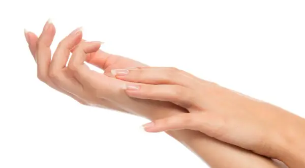 Dwie zadbane dłonie z paznokciami w stylu francuskiego manicure na białym tle.