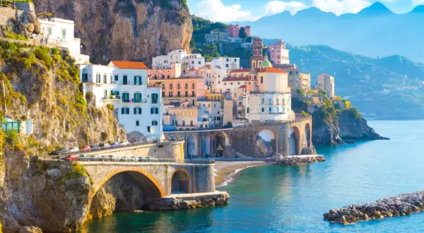 Widok na wybrzeże Amalfi z kolorowymi domami na klifie i mostem. Nawet przy takich widokach, objawy lęku przed ekspozycją na szlakach wybrzeża Amalfi a wyspa Capri mogą być odczuwalne.