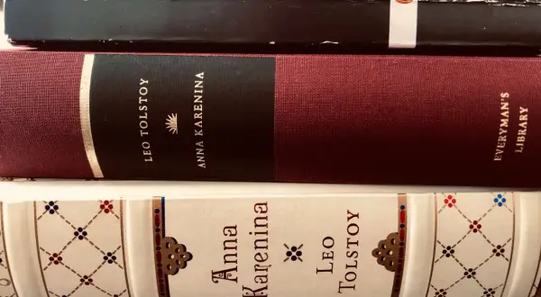 Trzy oprawione książki z tytułem "Anna Karenina" i nazwiskiem Lwa Tołstoja.