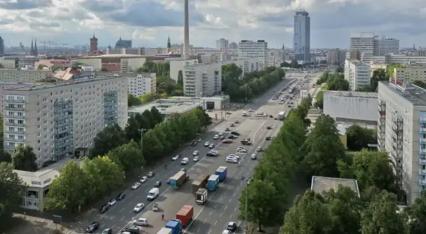 Blick über die Stalinallee in Berlin mit ihren charakteristischen Plattenbauten und viel Verkehr.