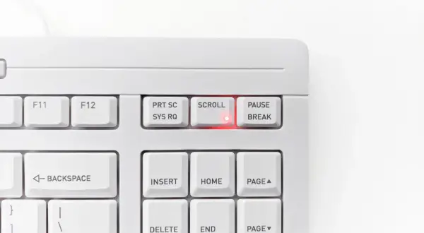 Biała klawiatura z podświetloną na czerwono diodą przy klawiszu SCROLL LOCK. Klawisz PAUSE/BREAK obok.