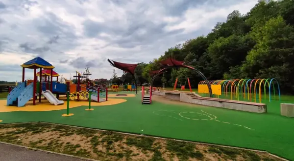 Kolorowy plac zabaw z mnóstwem atrakcji dla dzieci w Rzeszowie: zjeżdżalnie, huśtawki, tunele i ścianki wspinaczkowe.