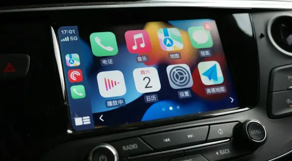 Ekran samochodu z ikonami Apple CarPlay. Jak włączyć tę funkcję? Zobaczysz tu telefon, muzykę, mapy i inne aplikacje.
