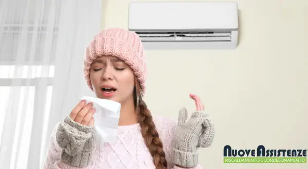 Donna con cappello e guanti di lana starnutisce, il condizionatore non fa aria fredda.