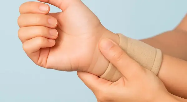 Mano con polsino elastico, che indica un possibile dolore al polso quando lo ruoto.